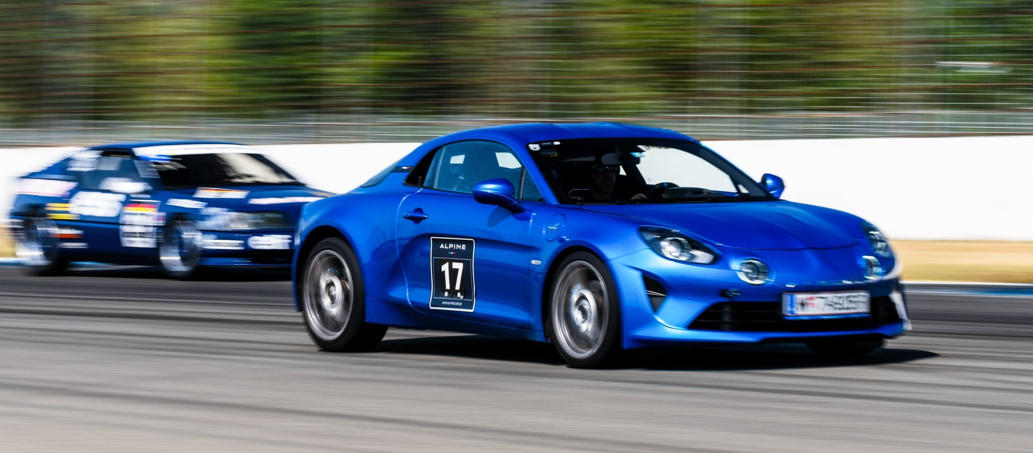 Alpine A110 beim Überholen auf der Rennstrecke von einer Alpine A310